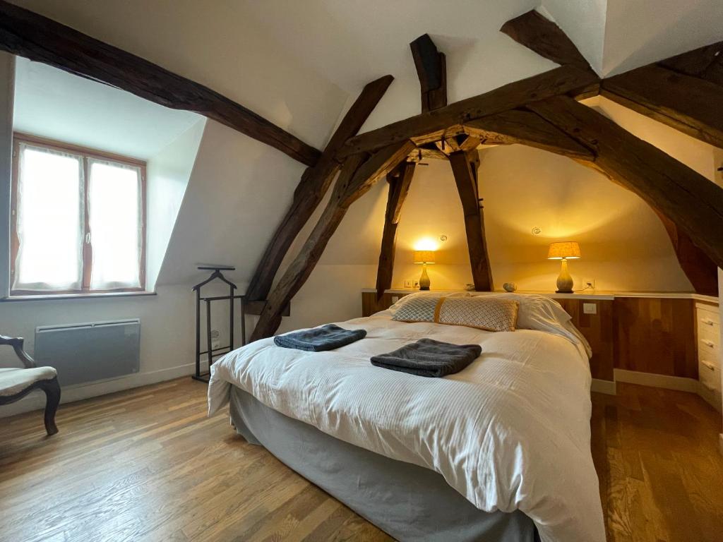 桑塞尔Maison Les Fossiles的一间卧室设有一张带木梁的大床