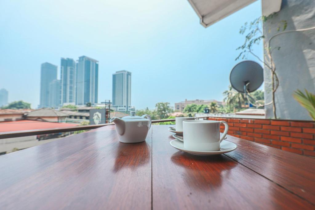 科伦坡Regent Residencies - Colombo的阳台上的木桌上放着两个咖啡杯
