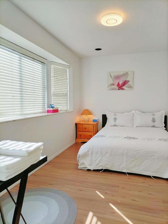 温哥华LLT HomeAway的卧室配有白色的床和窗户。