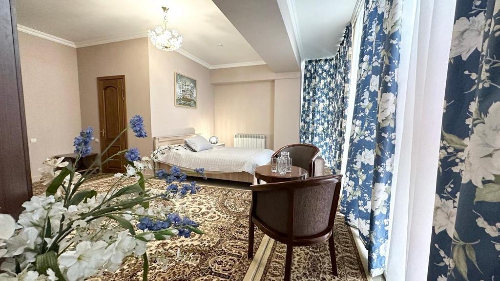 奇姆肯特Cannes Hotel的一间卧室配有蓝色和白色壁纸的床
