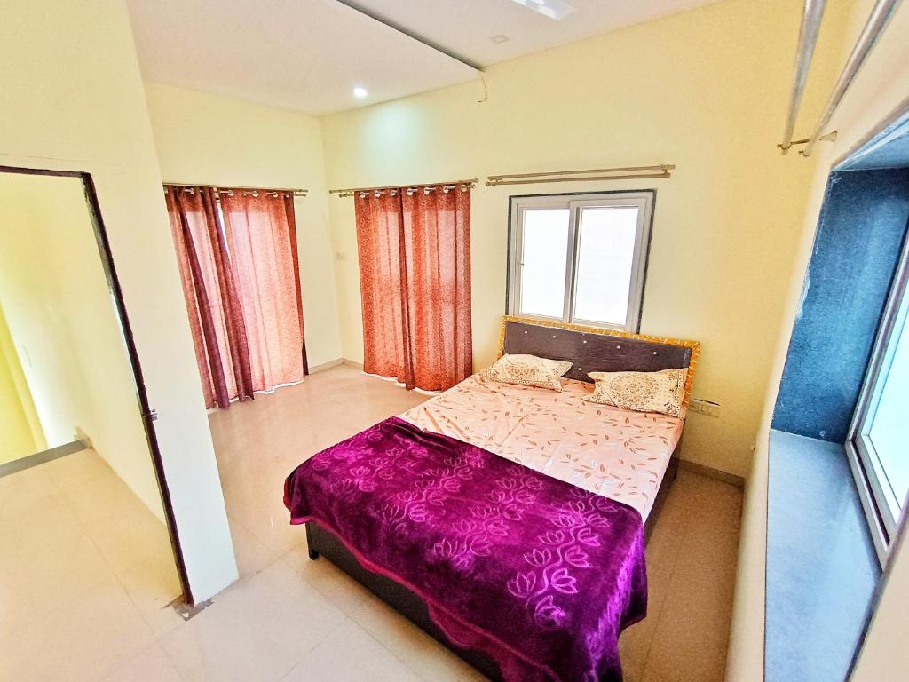 浦那CityAir的一间卧室配有一张带紫色毯子的床