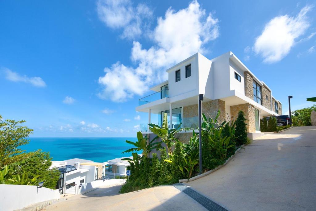 拉迈Villa The Wave 2 Residence的一座白色的房子,背景是大海