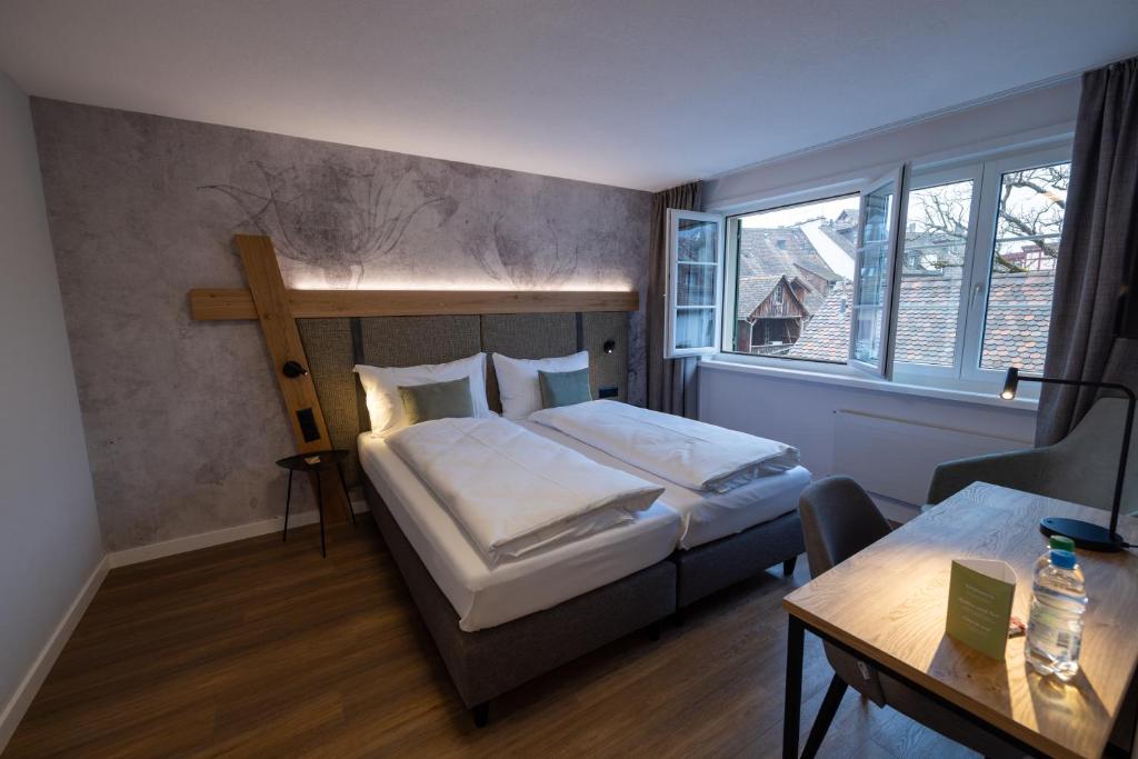 施泰因Hotel Adler的卧室配有一张床,墙上有十字架