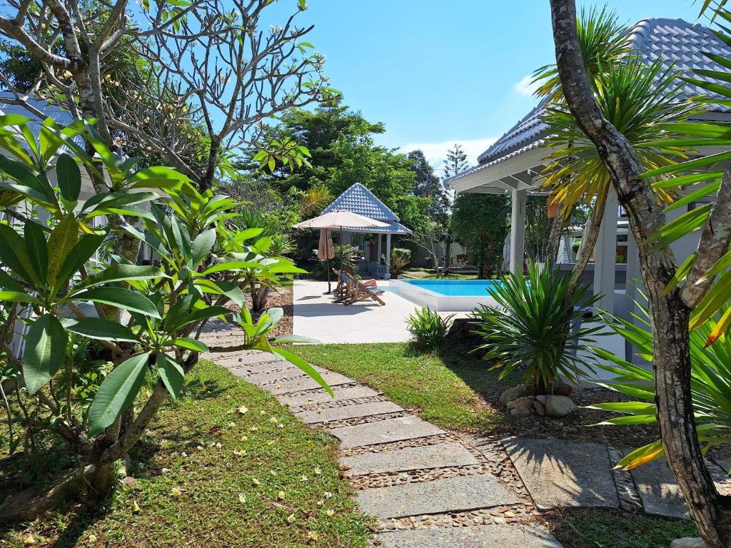 苏梅岛Thiptara Resort的一个带房子和游泳池的花园