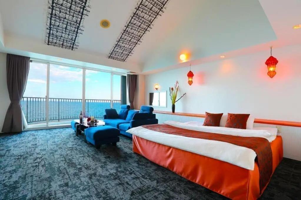 别府HOTEL CALM Leisure Hotel的酒店客房设有一张床和一个大窗户