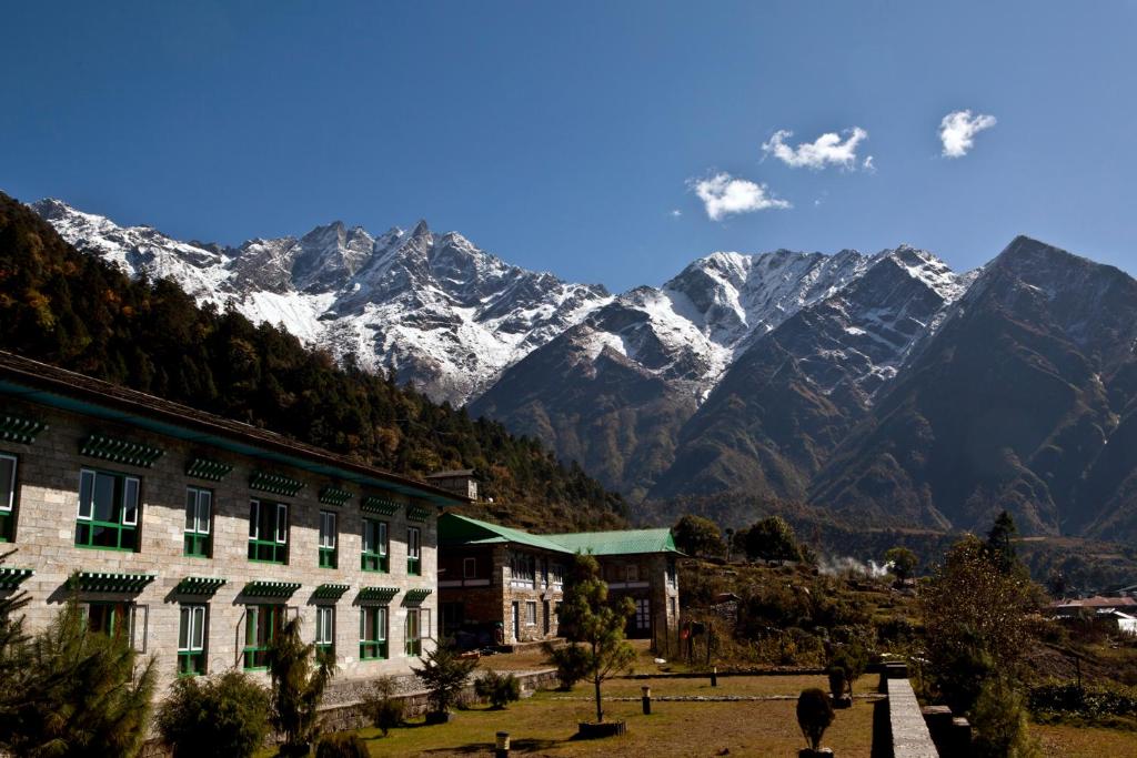 LuklaMountain Lodges of Nepal - Lukla的山前的积雪建筑