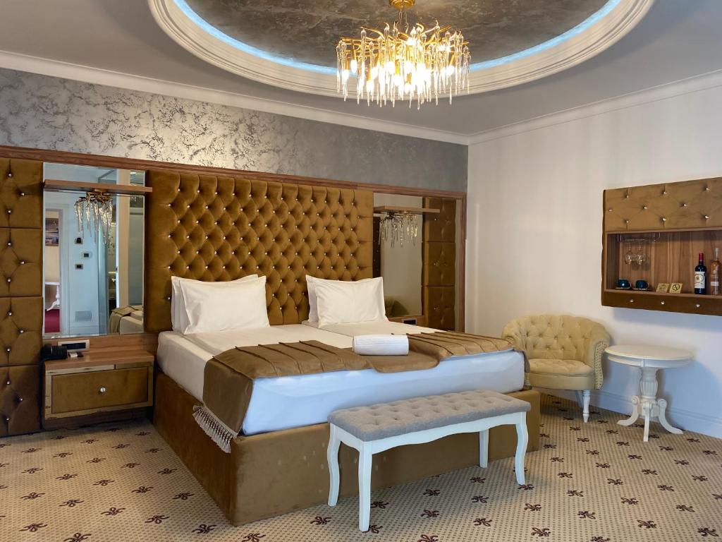 弗格拉什Vila Imperial One Luxury Boutique Hotel的一间卧室配有一张大床和一个吊灯。