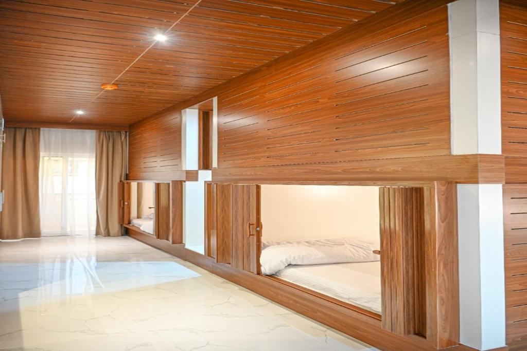迪拜Yoi Pod Hostel的木墙客房的一张床位
