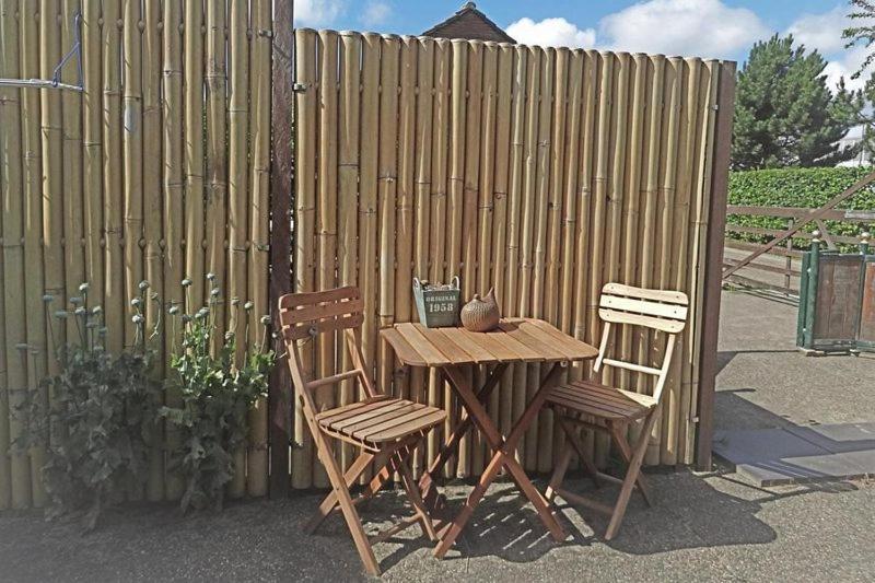 西姆斯科克B&B De BonAparte的木桌和两把椅子,围栏旁