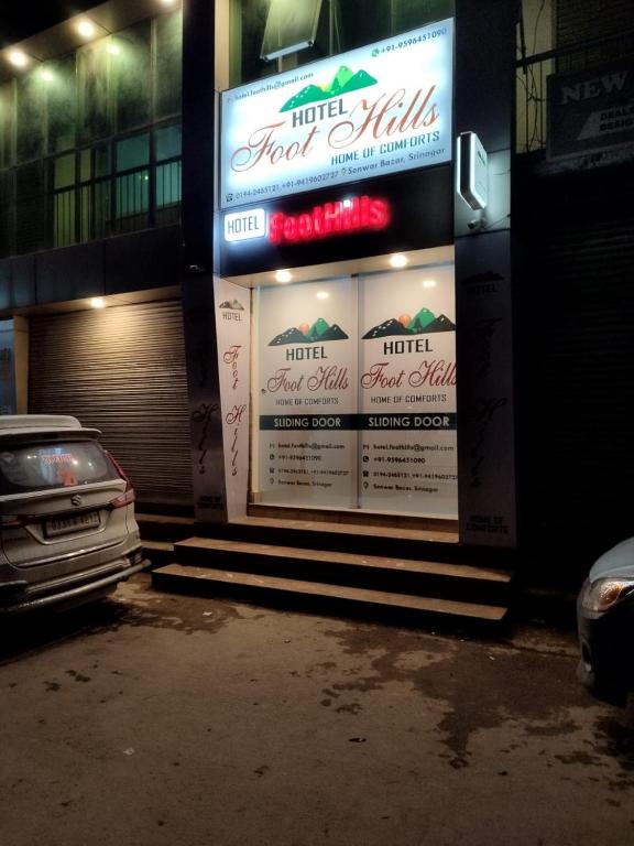斯利那加Hotel Foothills , Srinagar的前面有一个加油站,有一辆汽车停在