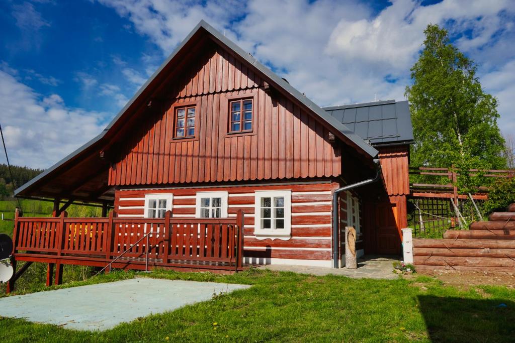 捷克布杰约维采Chata Říp的一座红色的小房子,设有木甲板