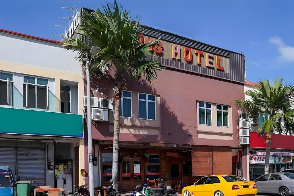 阿罗士打Fins Hotel的棕榈树城市街道上的酒店