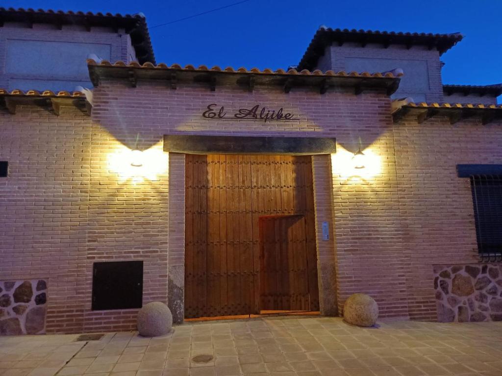 ArgésCasas Rurales El Aljibe, Jara的砖砌的建筑,有门,上面有标志