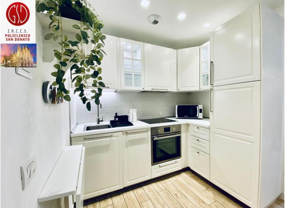 圣多纳托-米拉内塞NEW - Nuovo appartamento in centro的白色的厨房配有白色橱柜和水槽