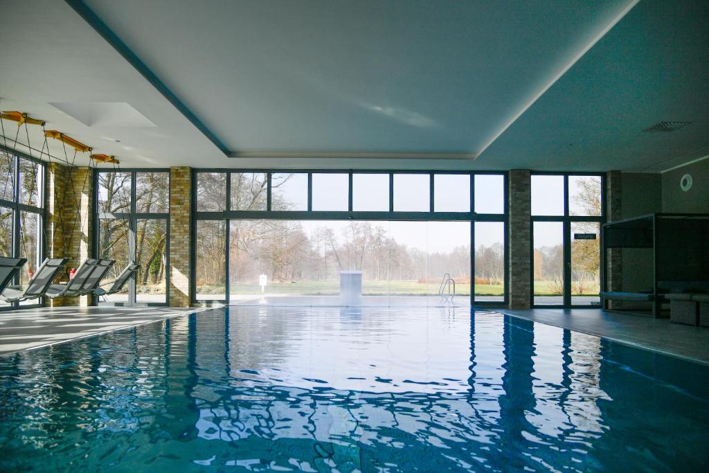 布尔格Landhotel Burg im Spreewald - Resort & Spa的大楼内带椅子的大型游泳池