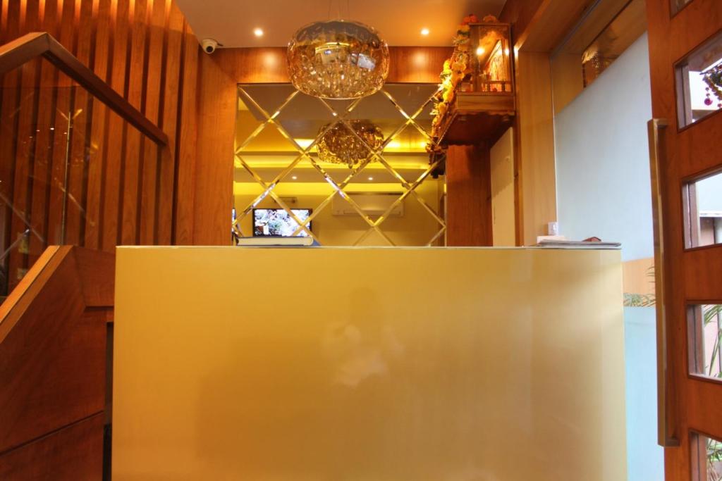 孟买MAROL METRO HOTEL MUMBAI的吊灯房间的一个黄色柜台