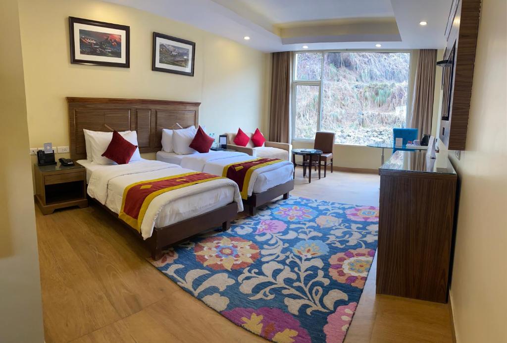 西姆拉Fortune Park Kufri, Shimla - Member ITC's Hotel Group的酒店客房设有两张床和窗户。