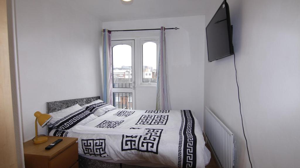 伯明翰3BED Maisonette Near CityCentre的一间卧室设有一张床、一台电视和一个窗口。