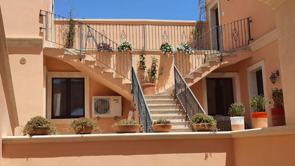 马里蒂玛Corte dei Fiori Acquaviva Apartments的一座种植盆栽植物的建筑中的楼梯