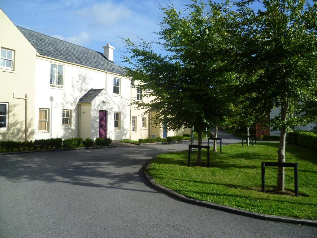 本拉提Bunratty Castle Gardens Home的街道前有树木的白色房子