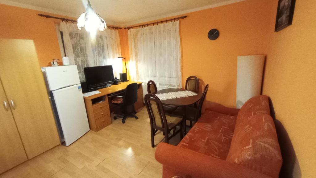 TrávnicaHannaH - Relax dom pod orechom Apartman2的带沙发、桌子和冰箱的客厅