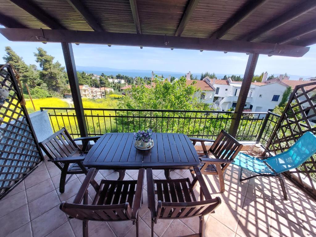 克里皮吉Grecia-Penisola Calcidica "My Romantic House Sea Wiew Terrace" Wi-Fi, BBQ, Garden,Parking的美景阳台配有蓝色的桌椅