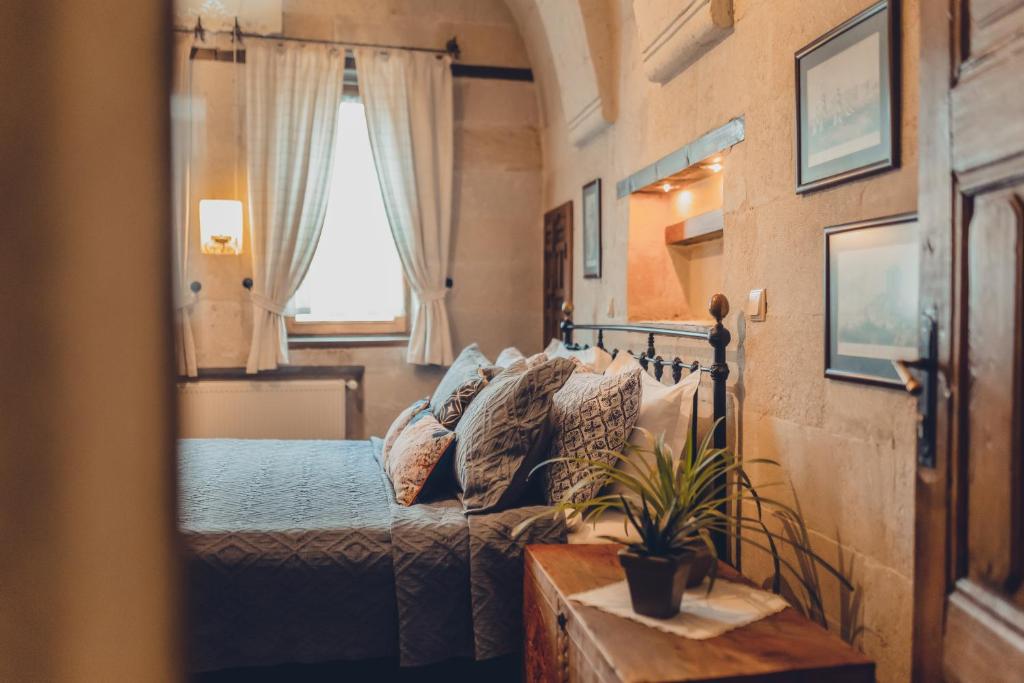 乌奇希萨尔Kale Konak Cappadocia的一间卧室配有一张床、一张沙发和一个窗口