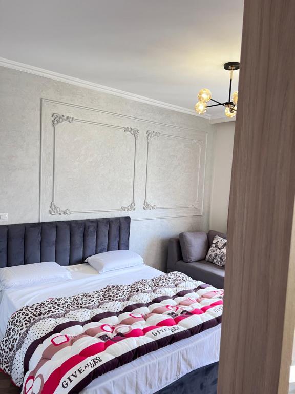 地拉那Experience New Bazaar Apartment 01的一间卧室配有一张床和一张沙发