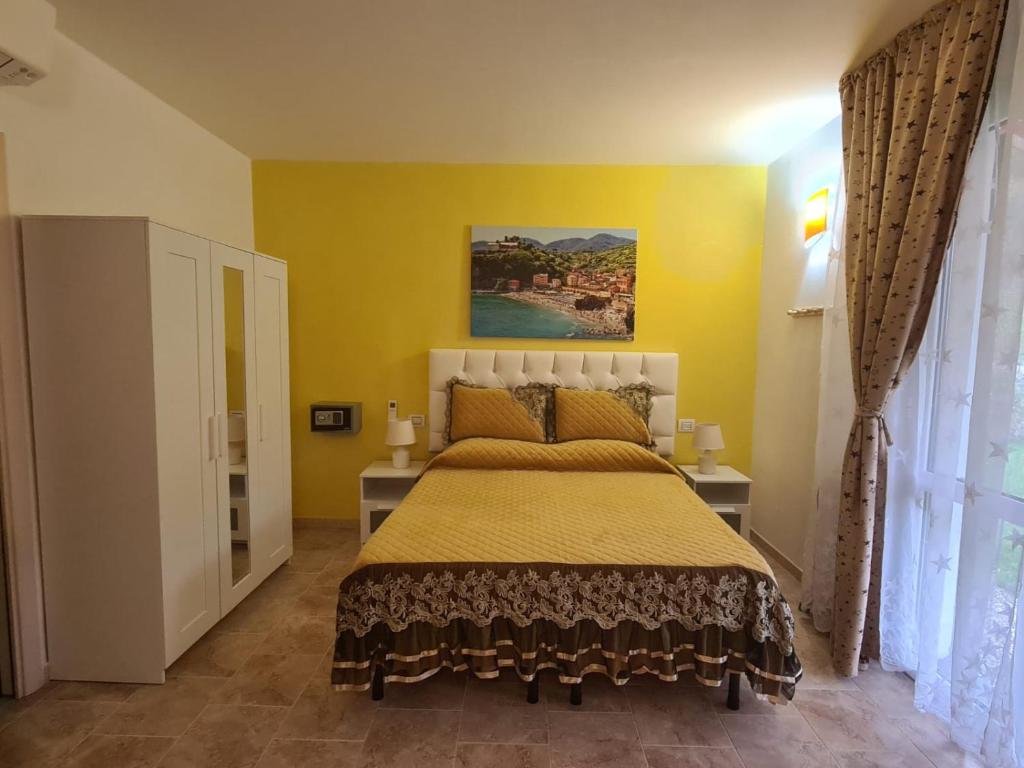 莱万托科利纳豪园农庄酒店的一间卧室设有一张黄色墙壁的大床