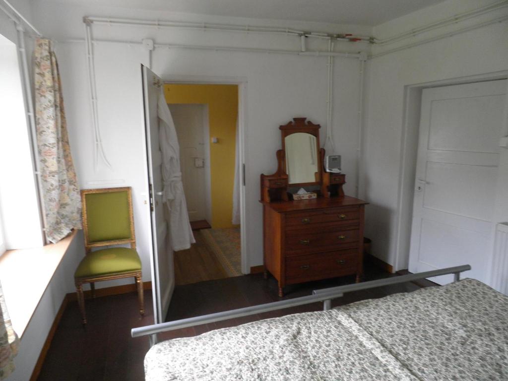 LubogoszczRetreat Resneva的一间卧室配有镜子、一张床和一把椅子