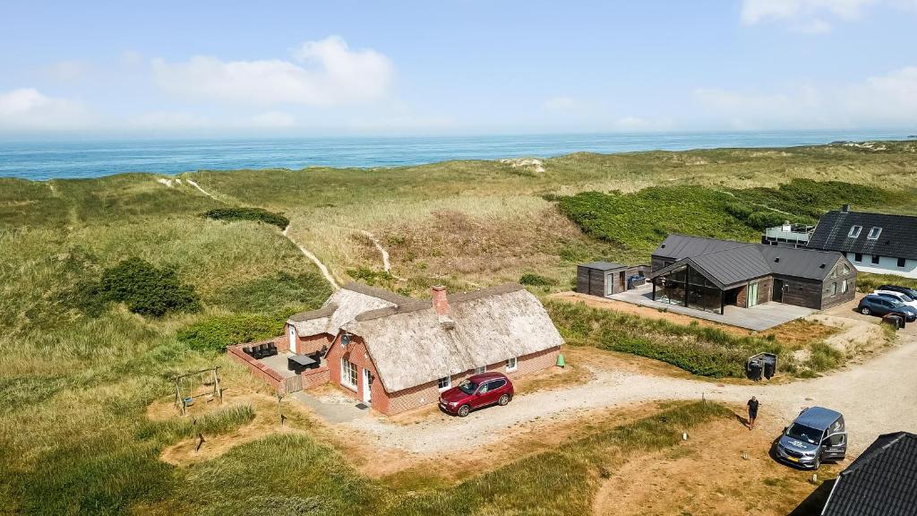 哈博尔Thatched house with spa and pool by the sea - SJ67的前面有停车位的房屋的空中景致