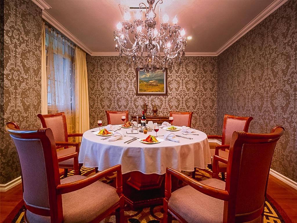 Darhan布黛酒店的一间带桌椅和吊灯的用餐室