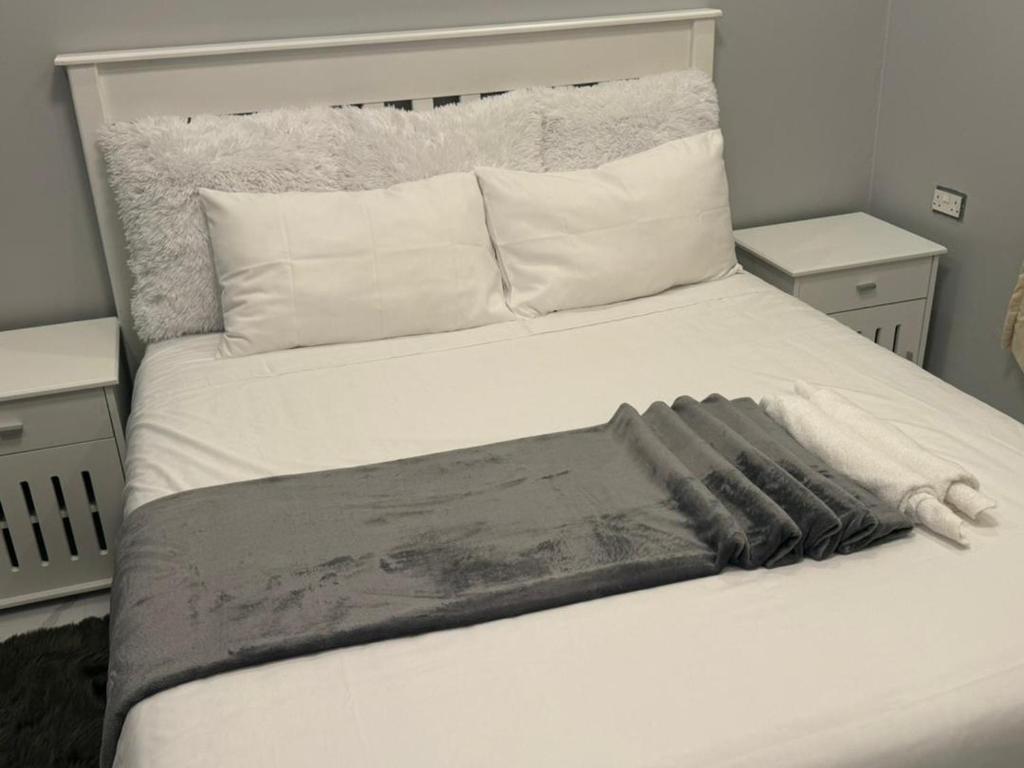 奇帕塔Modern Village Apartments的一张白色的床,上面有一条毯子
