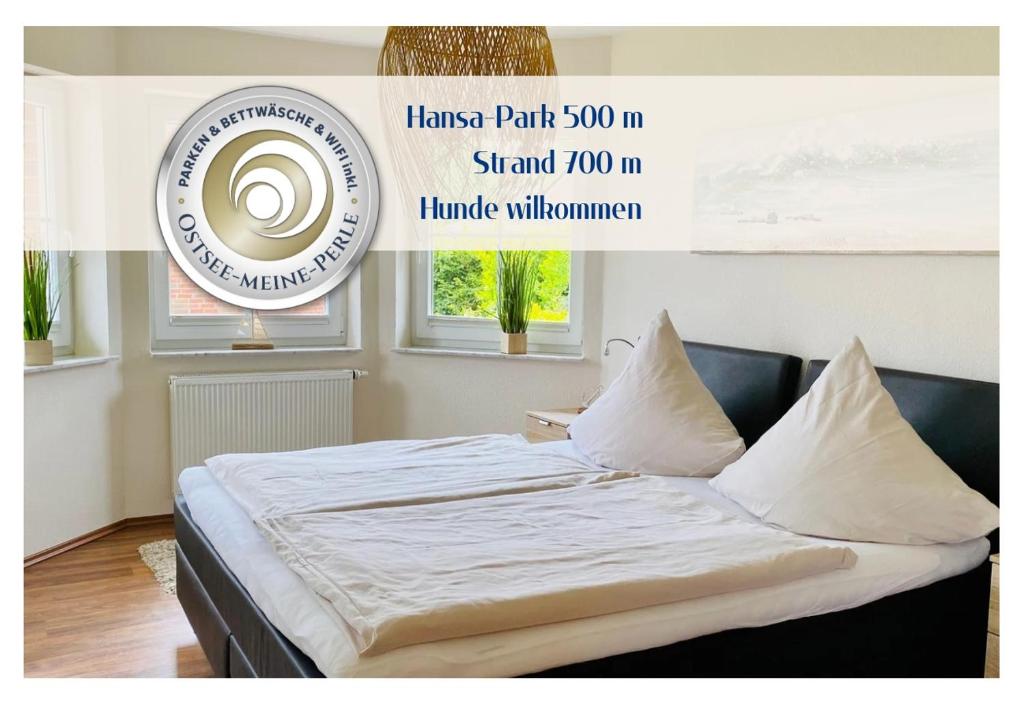 希尔克道夫FeWo PANORAMADECK Familien-strandnah-Garten-Hunde-Sport-und Schwimmbadnah-HansaPark的墙上有一张带海报的床铺