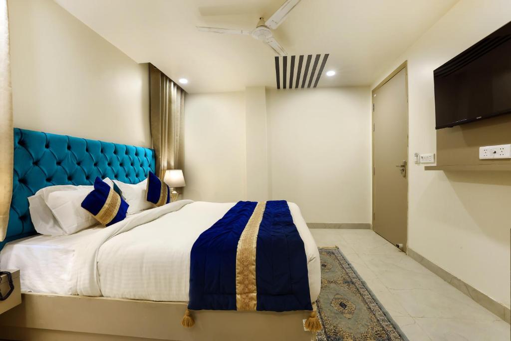 新德里Hotel Black Eye的一间卧室配有一张大床和蓝色床头板