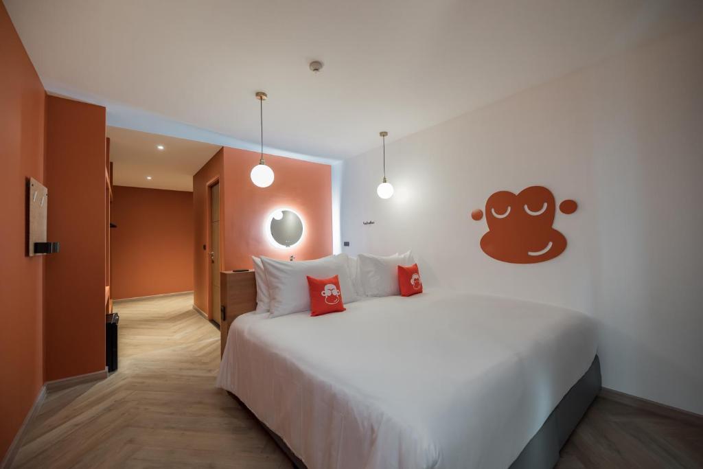 班邦森(1)Blu Monkey Hub and Hotel Bangsaen的卧室配有带红色枕头的大型白色床