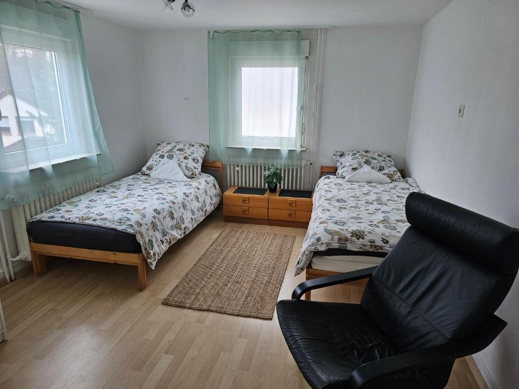 贝西格海姆Ferienwohnung im Besigheim的一间卧室配有两张床和椅子