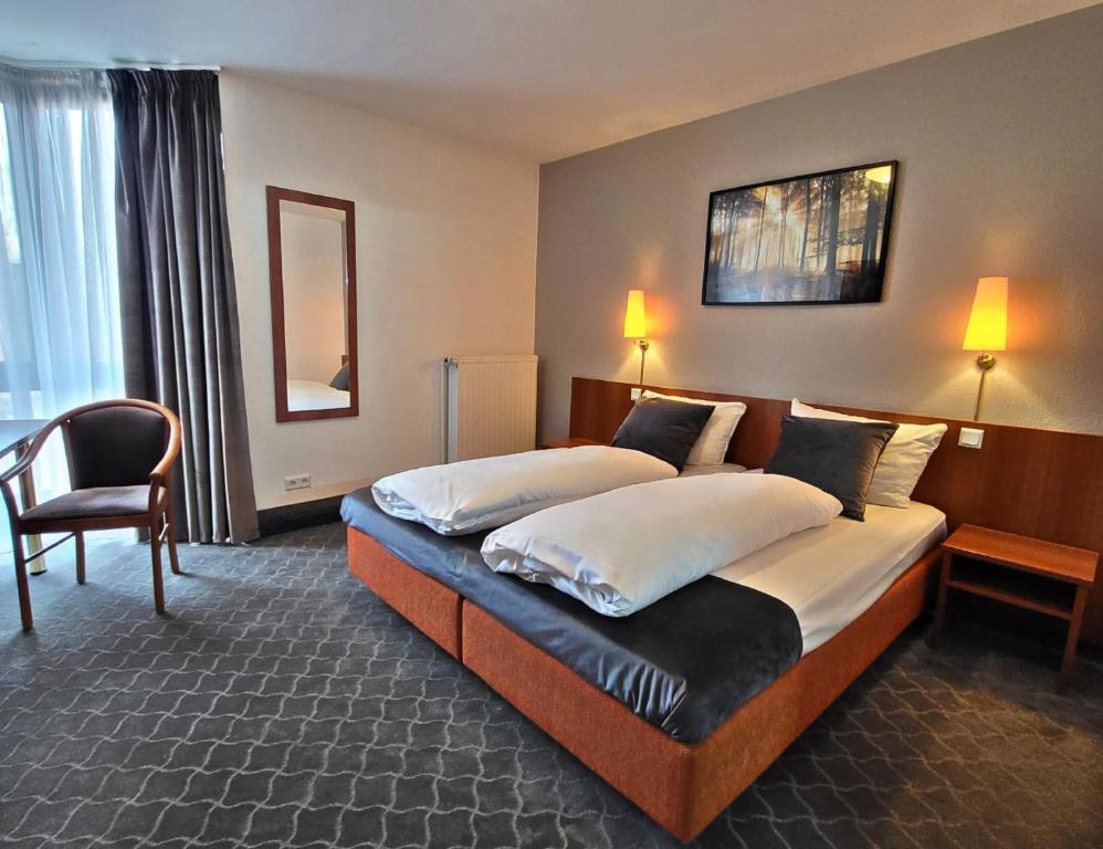 杜塞尔多夫阿斯科特康恩得酒店的酒店客房,配有两张床和椅子