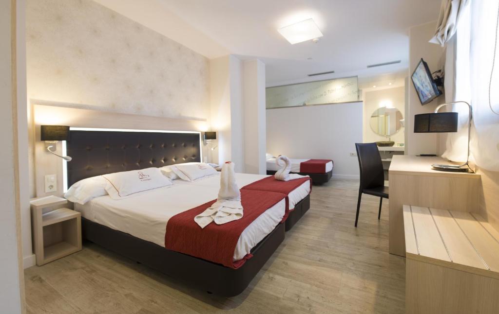 特鲁埃尔埃尔木达严酒店的配有一张床和一张书桌的酒店客房