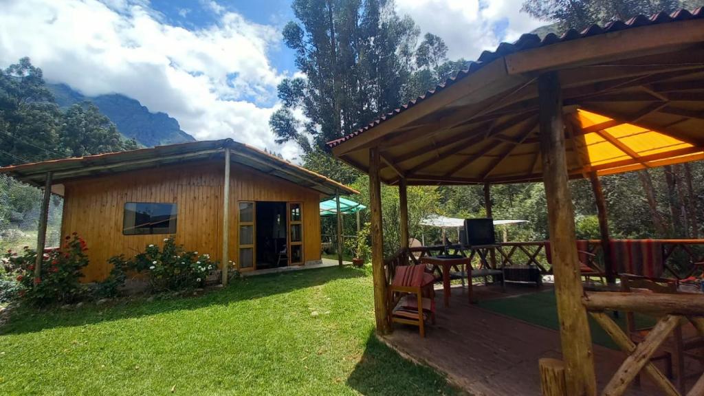 乌鲁班巴Eco Lodge Cabañas con Piscina的庭院内带桌椅的小木屋