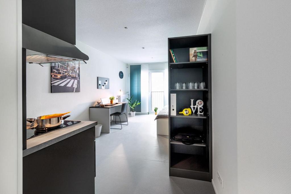 埃森Apartments Skyreach-WohnZimmer的厨房配有黑色橱柜和白色地板