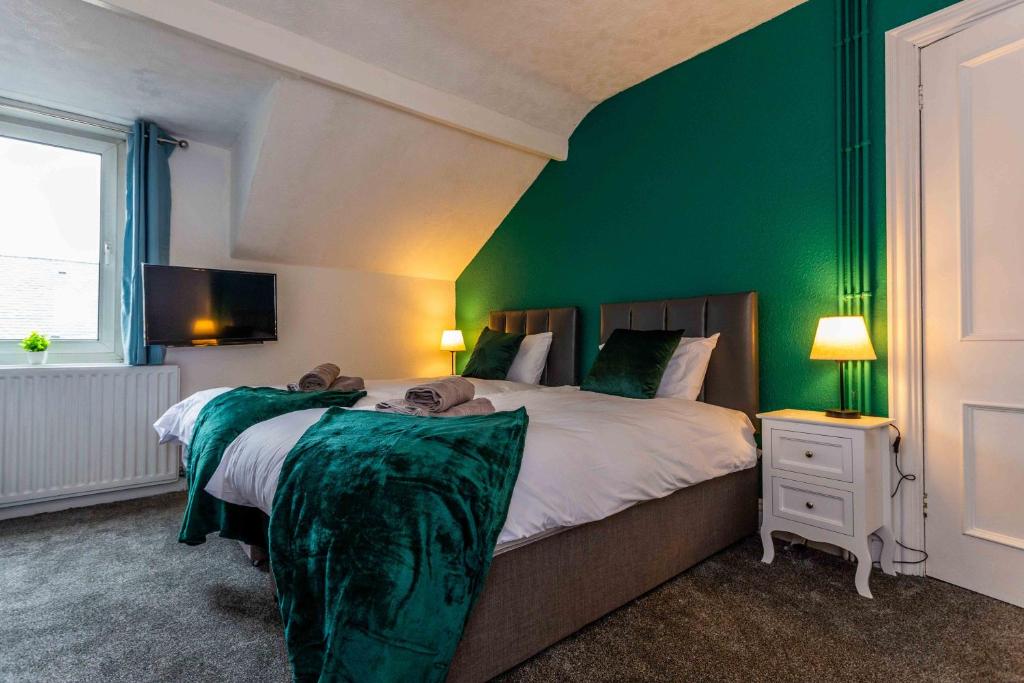 霍特惠斯尔Wonderful House near the Castle的一间卧室设有一张带绿色墙壁的大床