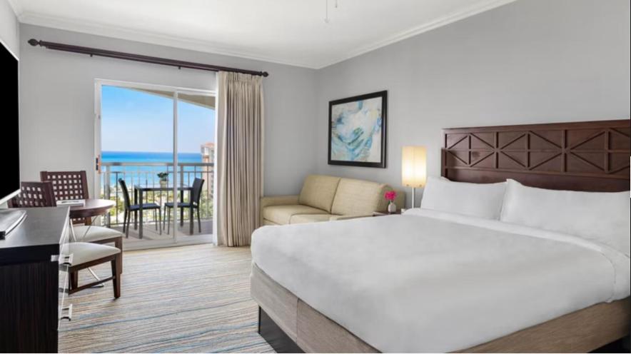 棕榈滩Hotel Aruba的酒店客房设有一张大床和一个阳台。