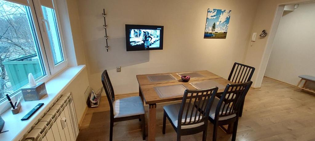 塔林Sääse 3 Apartment的一间带木桌和椅子的用餐室
