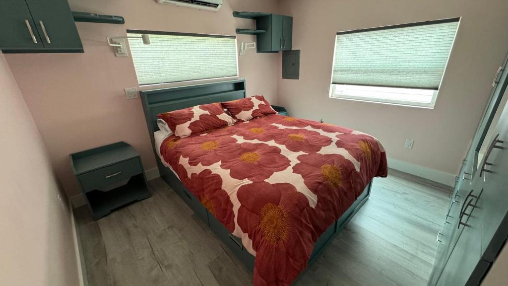 萨拉索塔Flamingo Tiny Home的一间卧室配有一张带花卉棉被的床