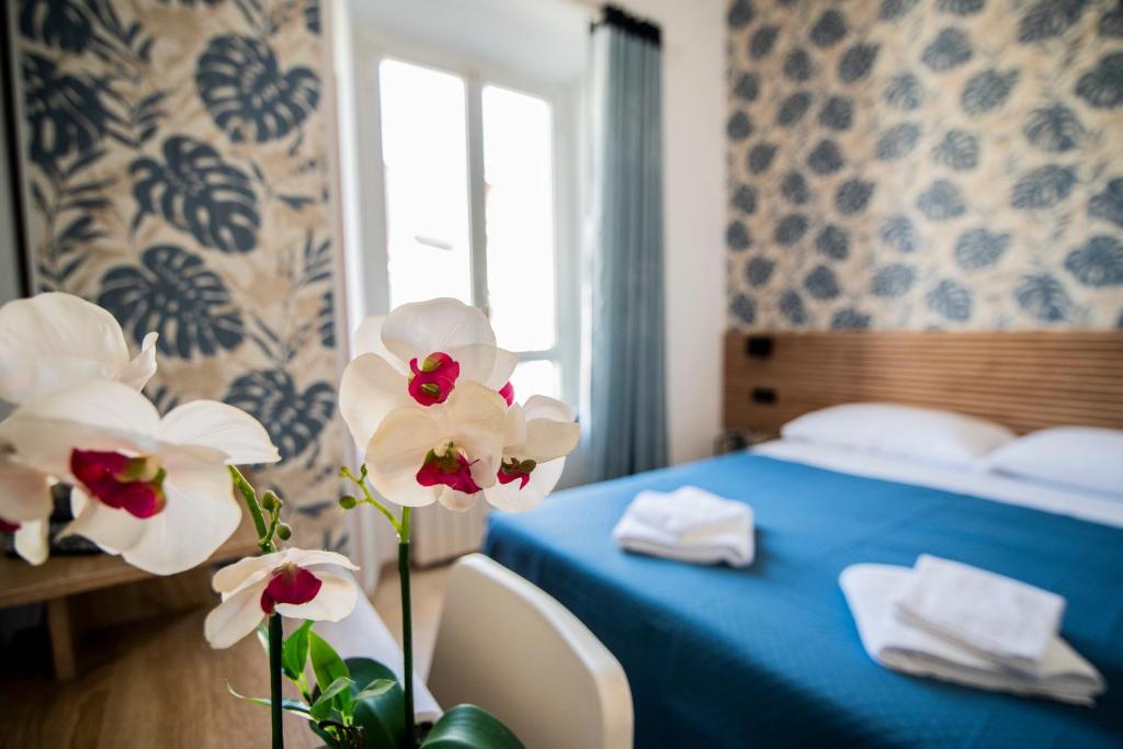 罗马德勒尔布酒店的蓝色的床和鲜花的酒店客房