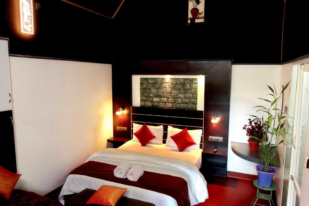 Anachalvattachalil villa的一间卧室配有红色枕头的床