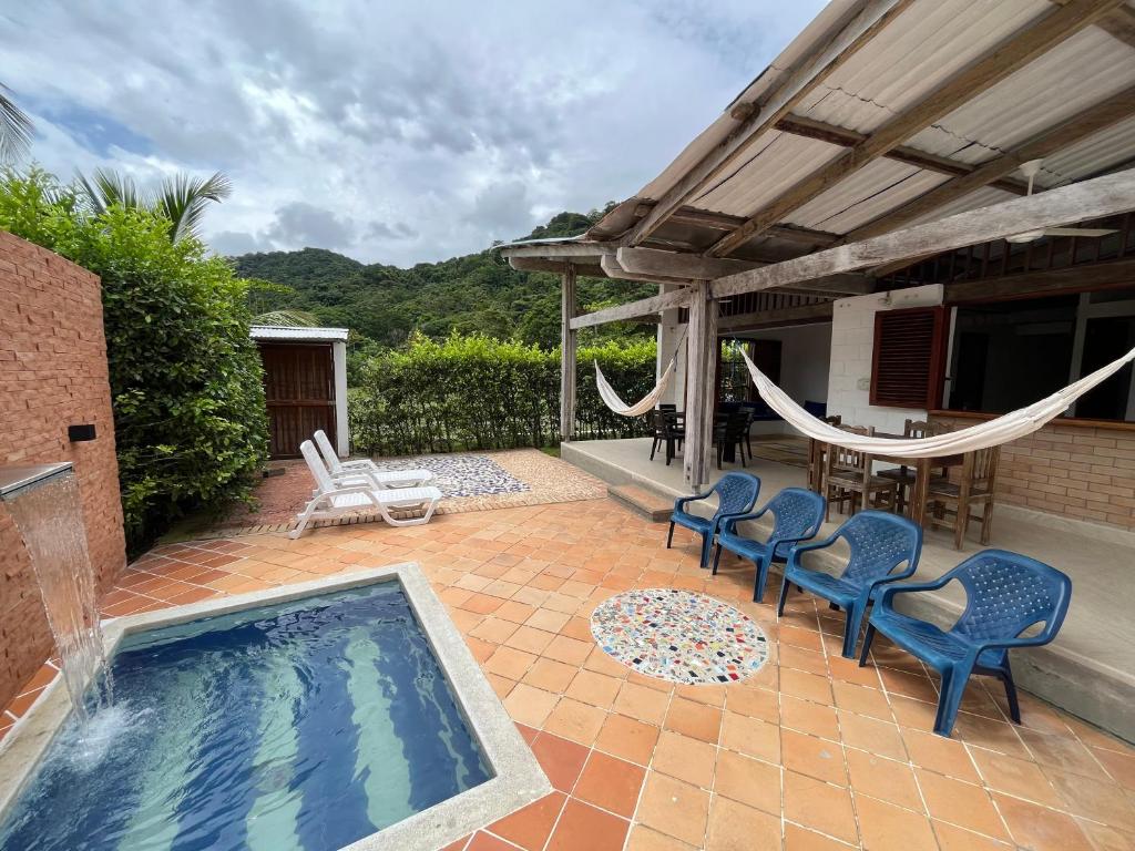 扎普祖罗Cabaña Pazatiempo Sapzurro的庭院设有游泳池、椅子和吊床。