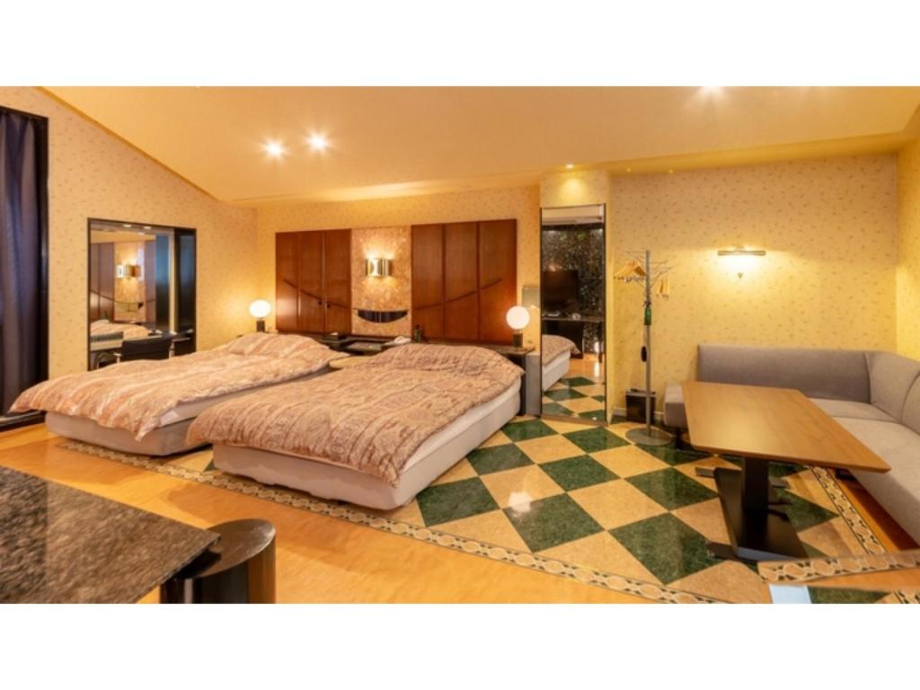 雫石町SHIZUKUISHI RESORT HOTEL - Vacation STAY 29563v的酒店客房设有一张大床和一张沙发。