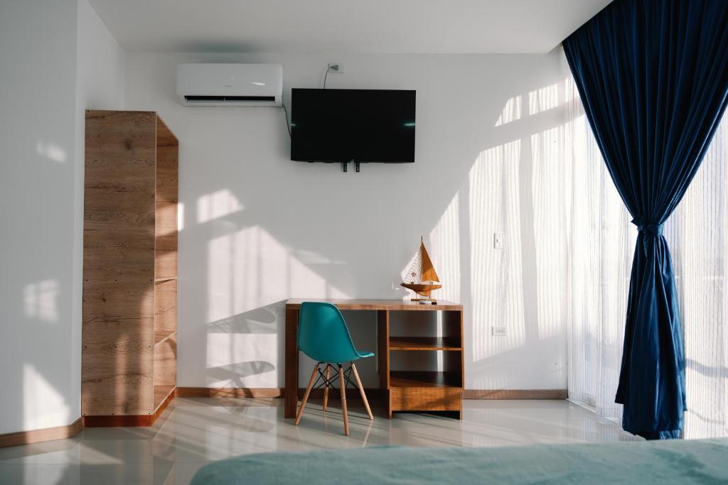 阿约拉港Modernas Habitaciones的一间卧室配有书桌和绿椅